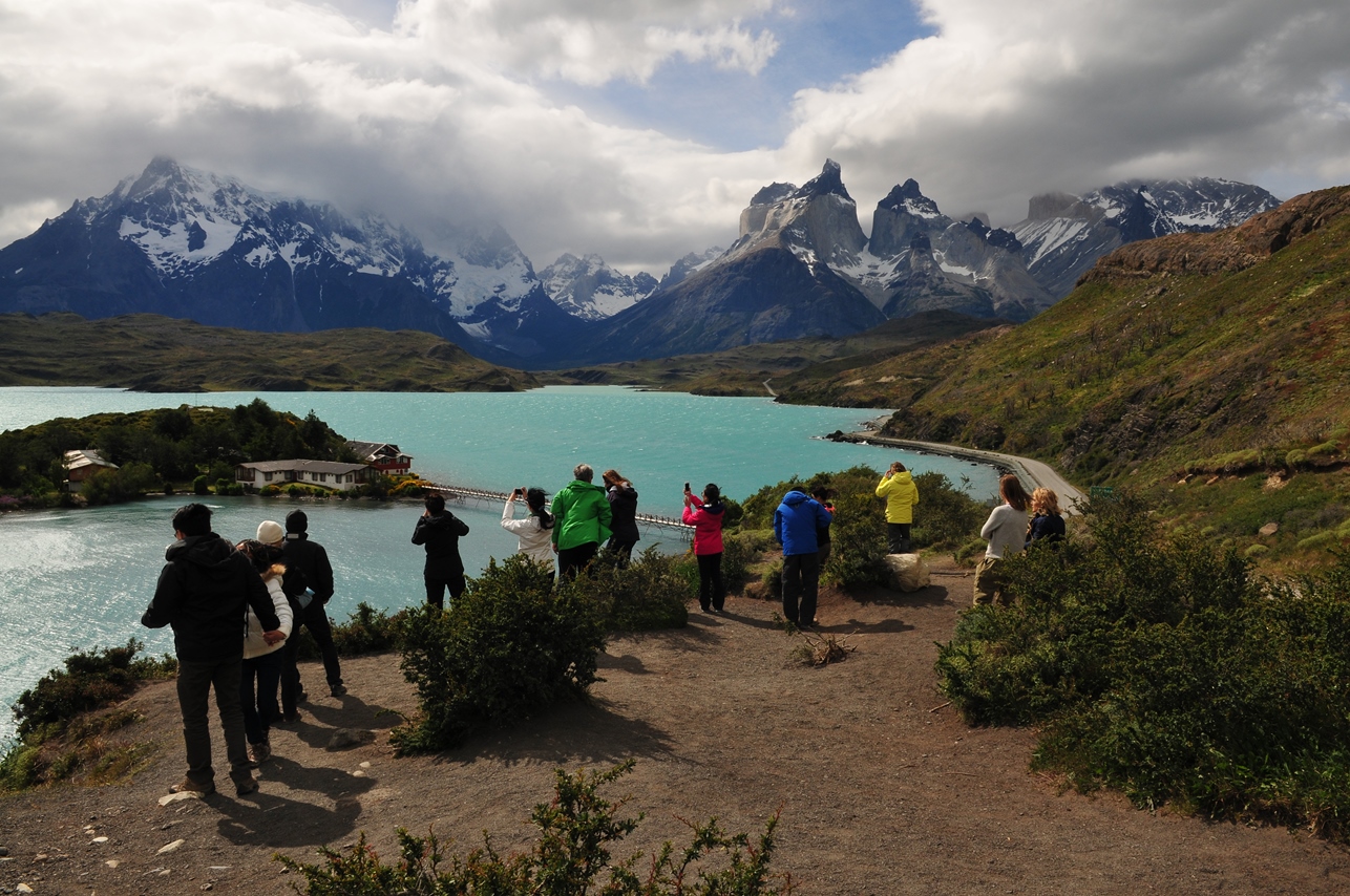 Visitantes contemplando el lago Pehoé y las montañas de Torres del Paine